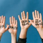 Four hands with messages against fascism for an activism campaign.